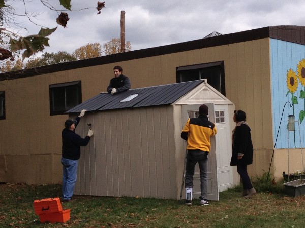 Young AFCEANs place the roof on an outdoor supply shed, which the chapter donated to Fort Belvoir Elementary School in November.